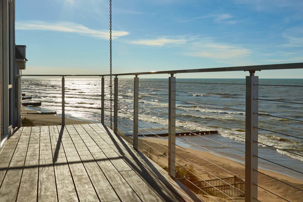 A ocean front deck with cable railings.