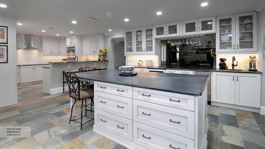White shaker style cabinets in a black and white kitchen.
