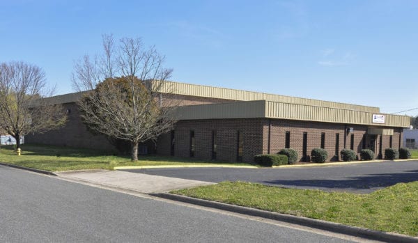 Richards Building Supply in Charlotte, NC. Brown brick building with light gray metal roof trim.