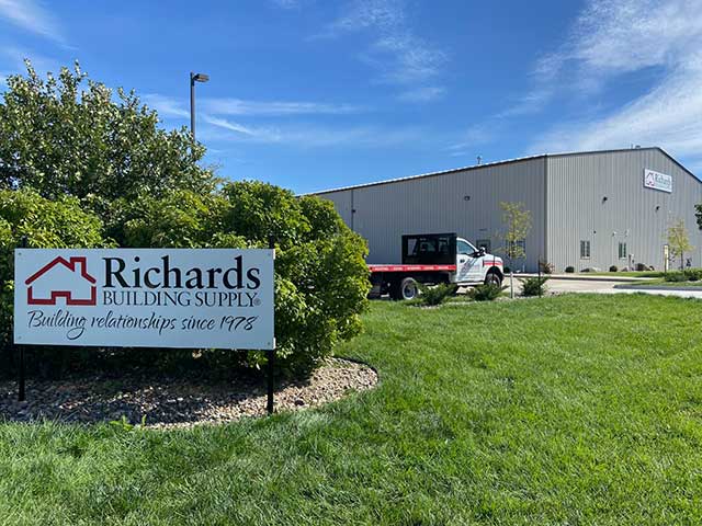 Richards Building Supply in DesMoines, IA. Single story, wide beige metal building with sign in front.
