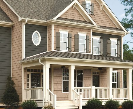 Close up photo of a green and beige house with our vinyl siding installed
