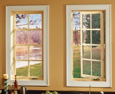 Example of 2 casement type windows with white trim against installed into a yellow wall.