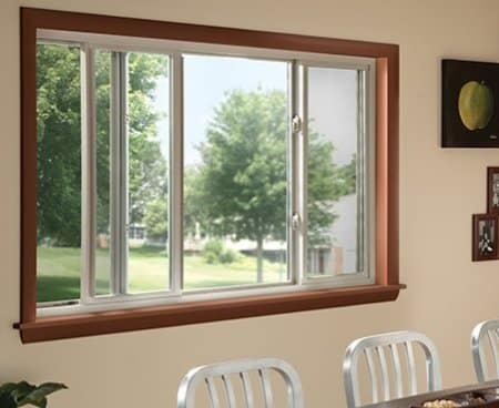 Example of sliding windows installed in an interior beige wall with brown trim.