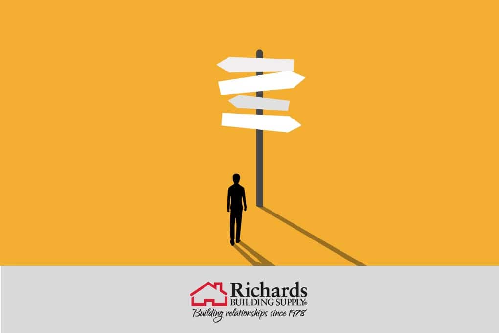 A figure standing in front of a signpost with multiple signs pointing in different directions.