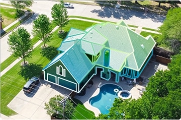 Aerial view of house with trees and a pool
